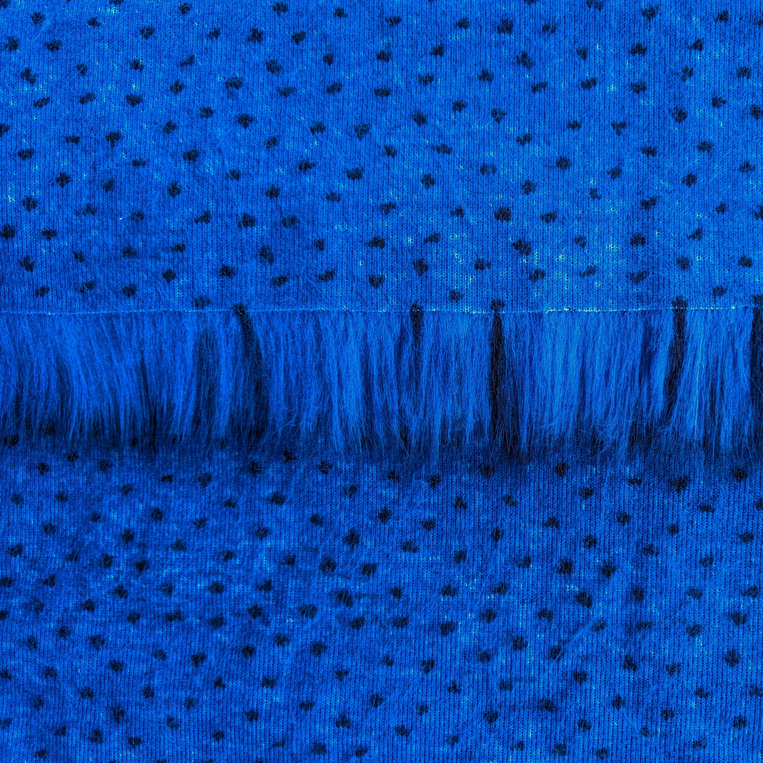 Backing of cobalt blue faux fur fabric showing the long pile length of the fake fur.