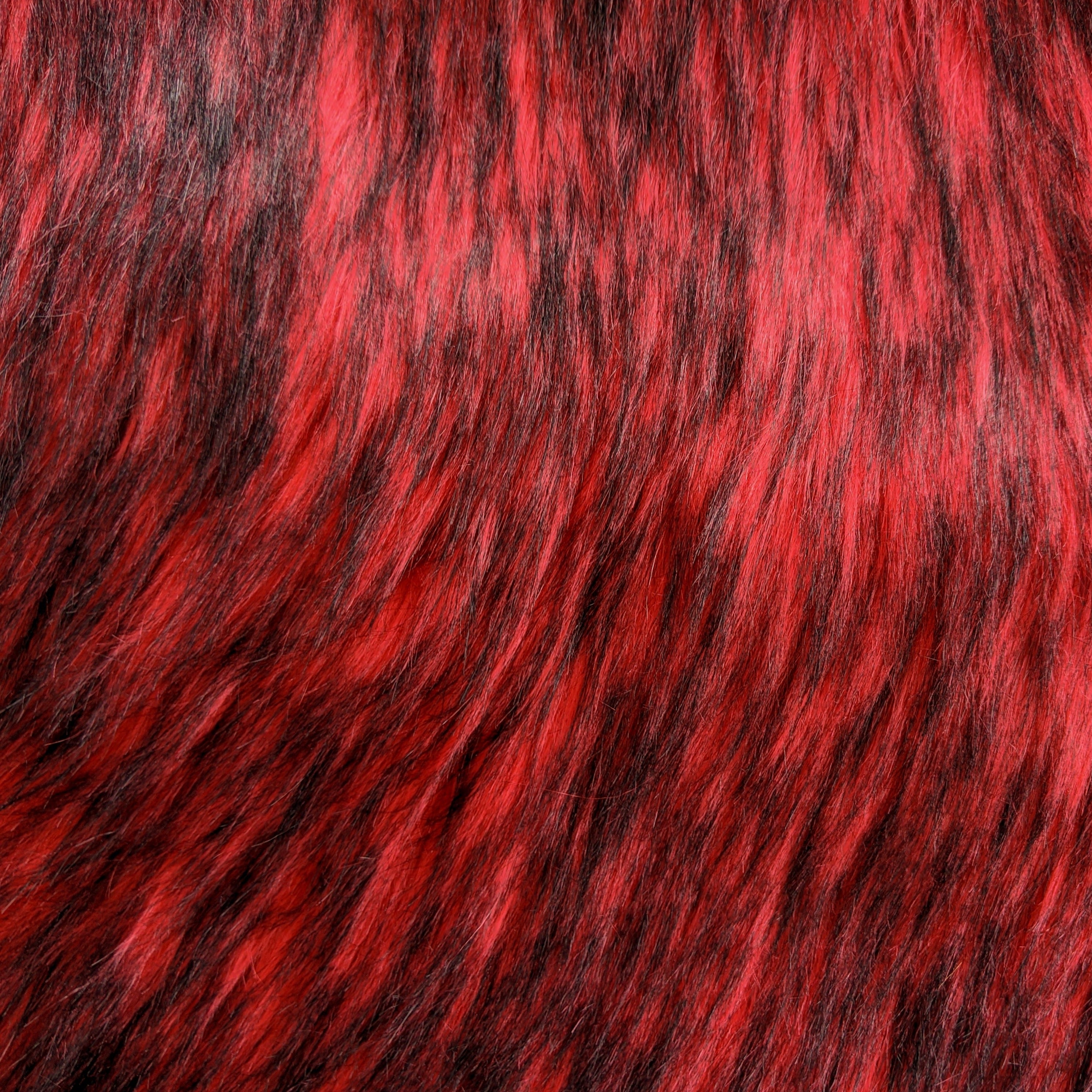 Long pile fire red faux fur fabric laid flat.