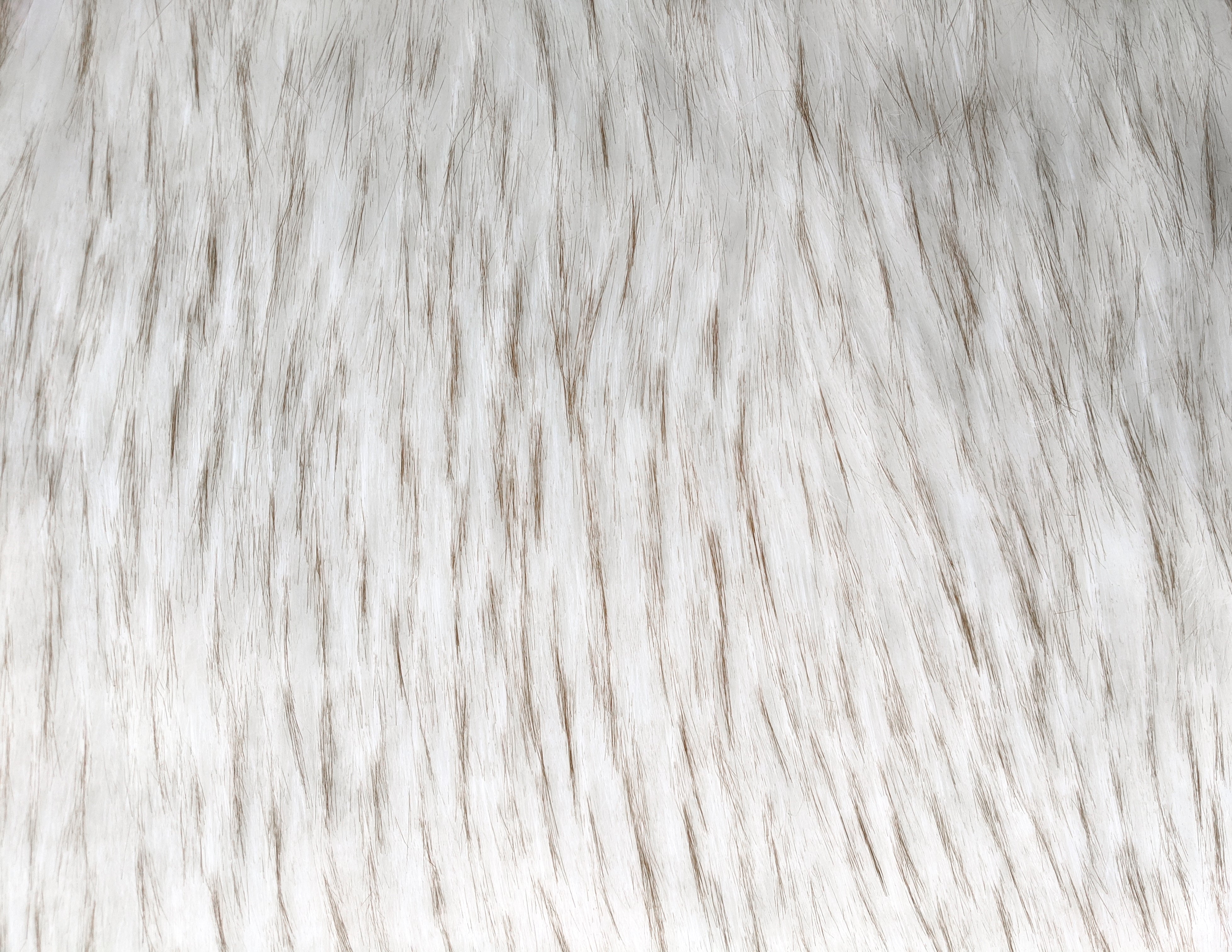 Long pile natural white faux fur fabric laid flat.