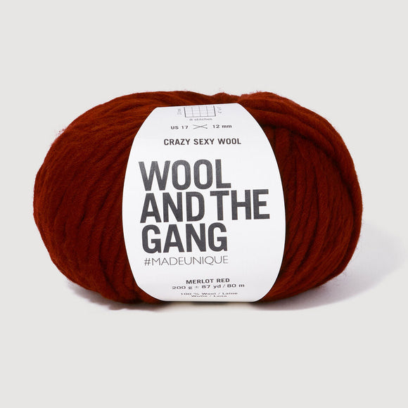 Red skein of yarn with 'Wool and the Gang' label on a white background