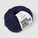 Navy blue skein of yarn with 'Wool and the Gang' label on a light gray background