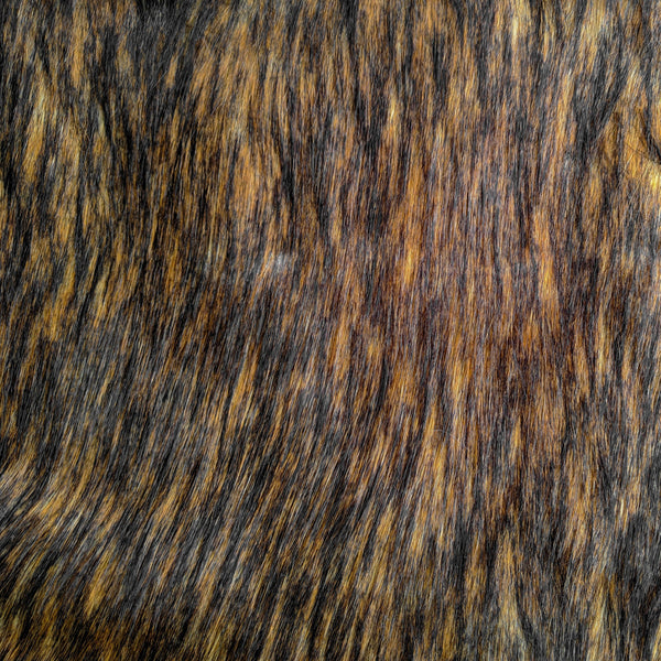 Chestnut is a long pile natural brown faux fur fabric laid flat in this picture.