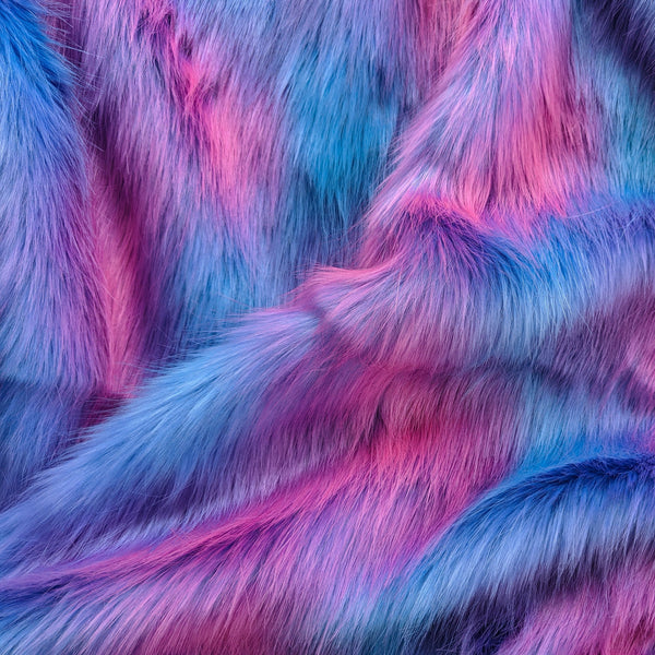 Dreamsicle faux fur fabric with folds.  Dreamsicle has a light blue base with pink and purple streaks as a long pile fake fur fabric.