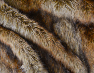 Golden brown faux fur fabric with folds.  A natural brown long pile fake fur fabric.