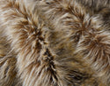 Grizzly brown faux fur fabric with folds.  A natural grizzly brown long pile fake fur fabric.