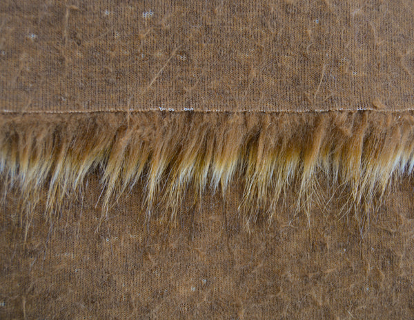 Backing of grizzly brown faux fur fabric showing the long pile length of the fake fur.
