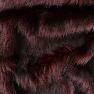 Merlot faux fur fabric with folds.  A burgundy long pile fake fur fabric.