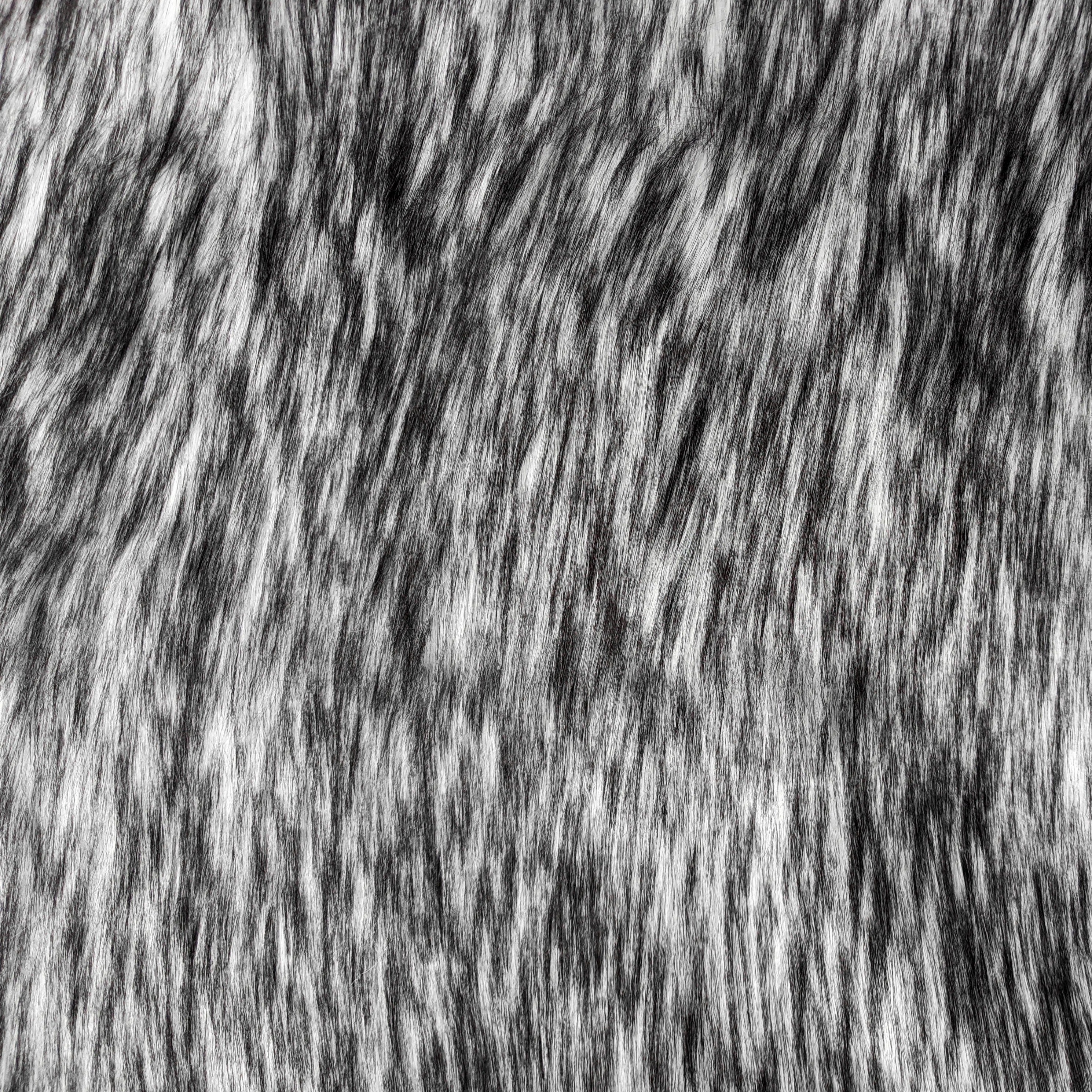 Long pile quartz faux fur fabric laid flat. Quartz is a black and white fake fur fabric.