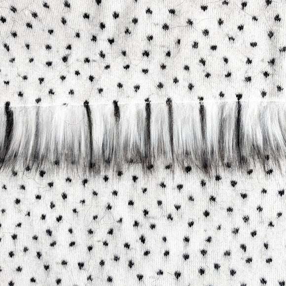 Backing of quartz faux fur fabric showing the long pile length of the fake fur. Quartz is a white faux fur with black tips running throughout.