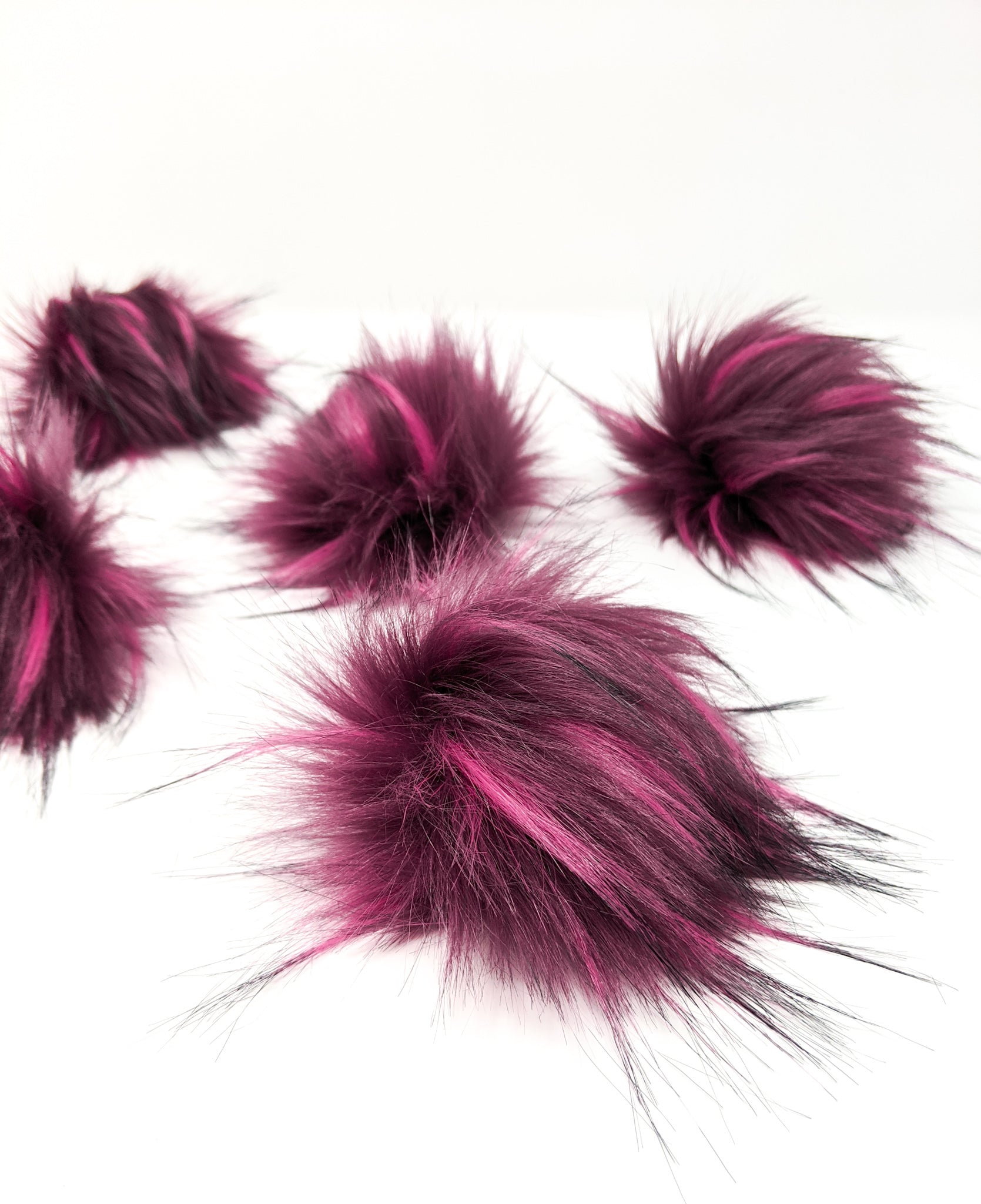 Raspberry faux fur pom poms.