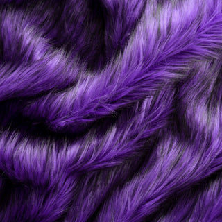 Violet purple faux fur fabric with folds.  A purple long pile fake fur fabric.